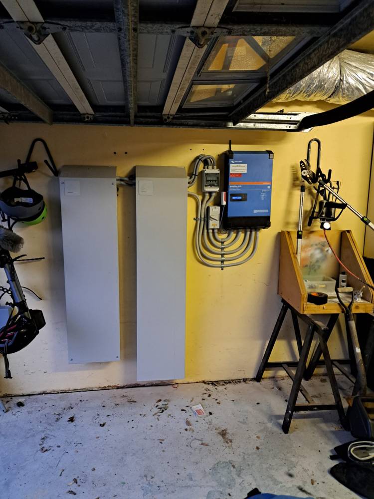 A 20 kWh installation of two battery cabinets and an inverter in an under-house workshop
