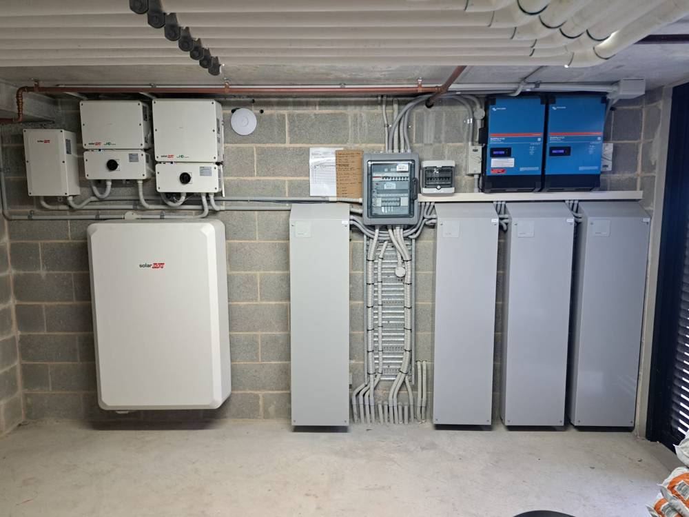 A 40 kWh Upcycle installation of four cabinets and two inverters, with an existing wall-mounted SolarEdge battery to the left