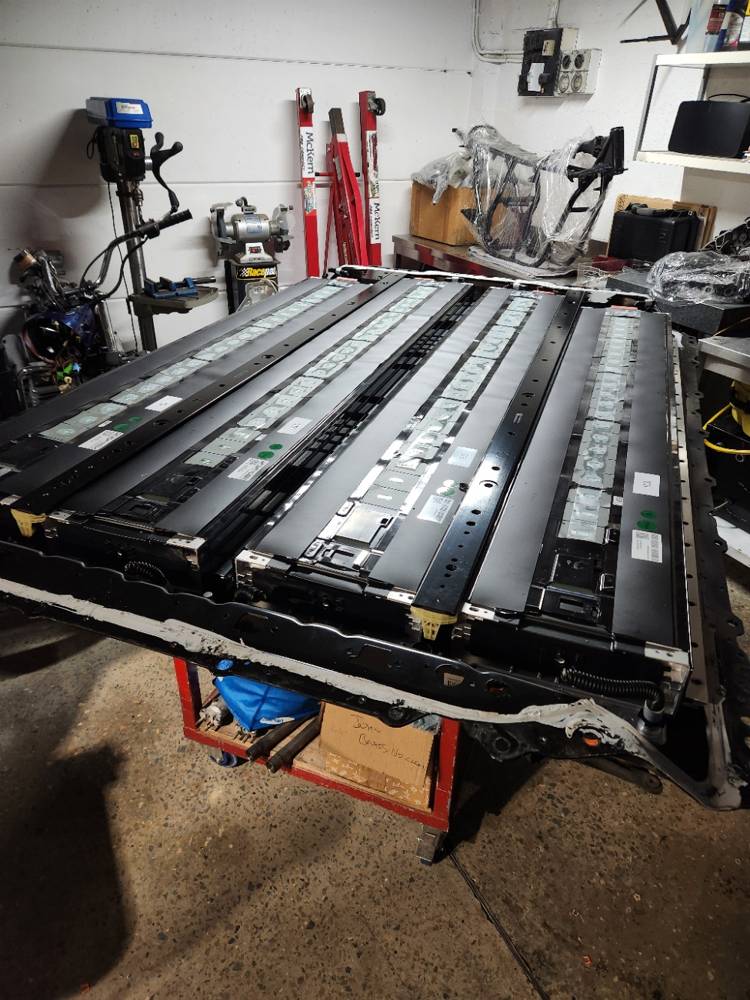 An LFP traction pack opened on a workshop bench with its modules exposed